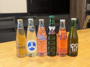 モモタロの木製カウンターに並ぶ6本の瓶入りドリンク
