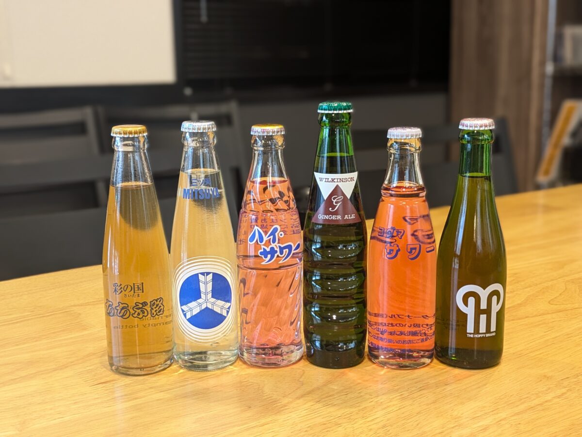 モモタロの木製カウンターに並ぶ6本の瓶入りドリンク