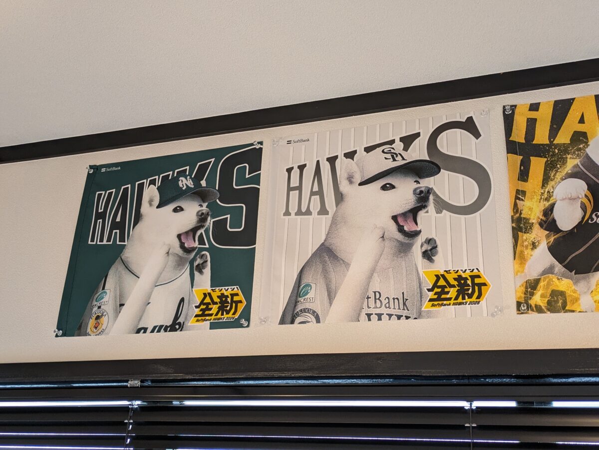 モモタロの店内の壁に、ほかのお父さんのフラッグと並べて飾った南海ホークスの応援フラッグ